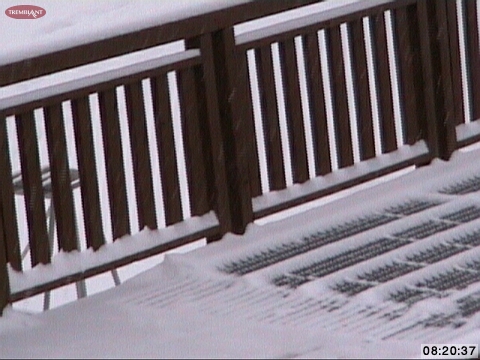You can see the accumulated amounts on the railings here and if you look closely, you will see small diagonal white streaks against the dark backgrounds in this snap shot which is the snow falling right now.